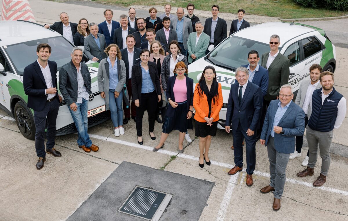 eTaxi Austria project participants at the test site with the two test vehicles Hyundai IONIQ 5 and VW ID.4 and the Matrix Charging Pad flush integrated into the car park surface (©Nicole Viktorik, 09.06.2022)